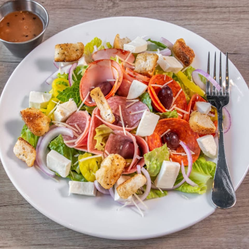 Ember + Ale's vibrant Italian salad with pepperoni, salami, cheese, croutons, and dressing.